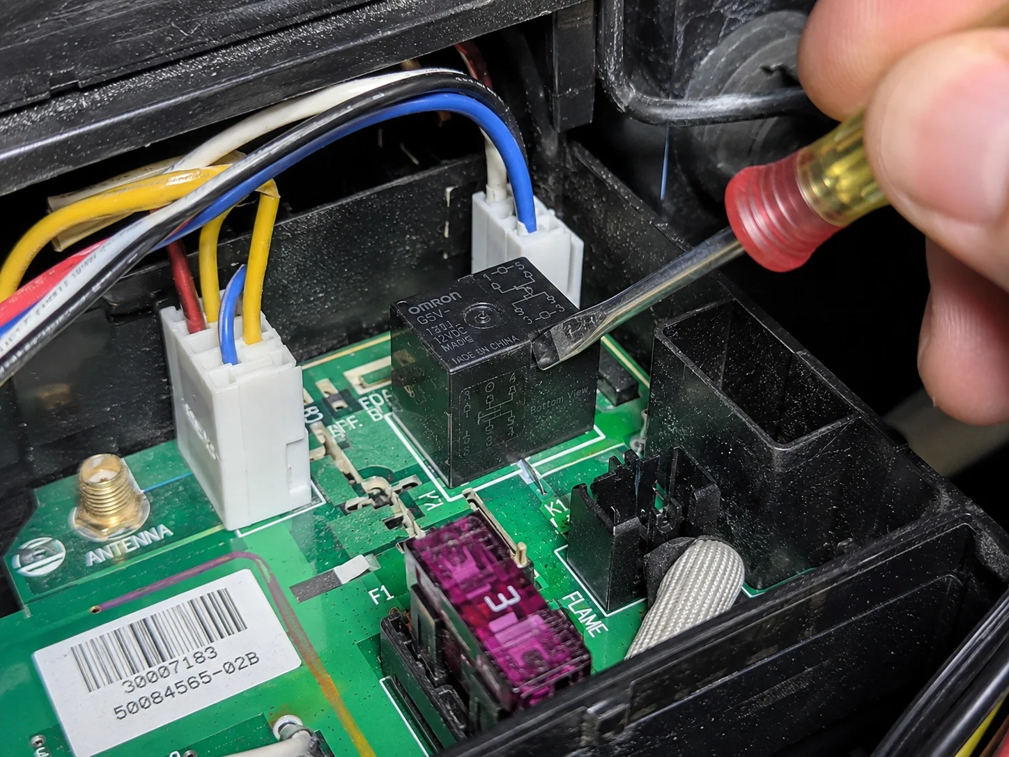 Internal view of a gas fireplace control module with a stuck relay