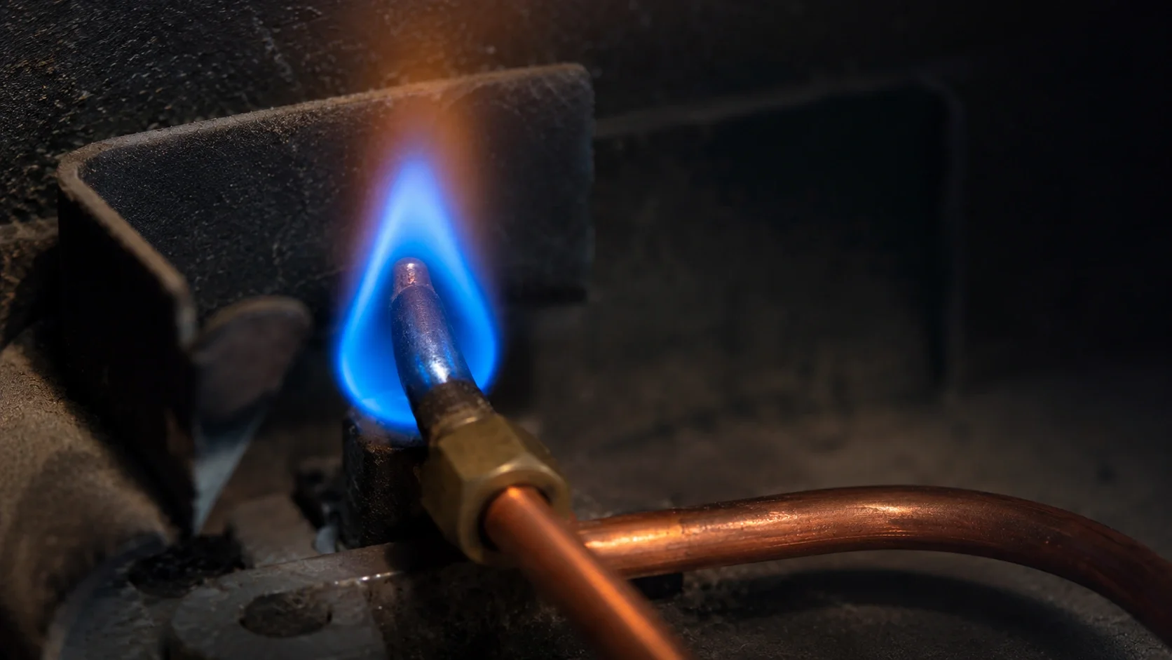 Close-up view of thermocouple and pilot light assembly in a gas fireplace
